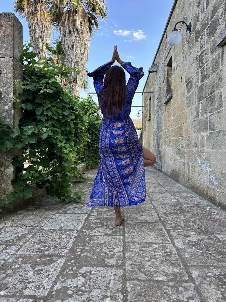 Saluto con le mani giunte sopra il capo, pratica di yoga negli spazi della Masseria Montanari